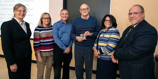 Five people presenting an award to Professor of History Robert Maxon